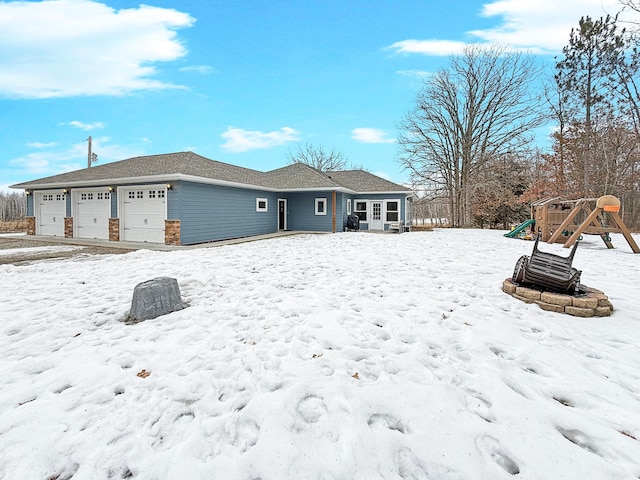 snow covered rear of property with a playground