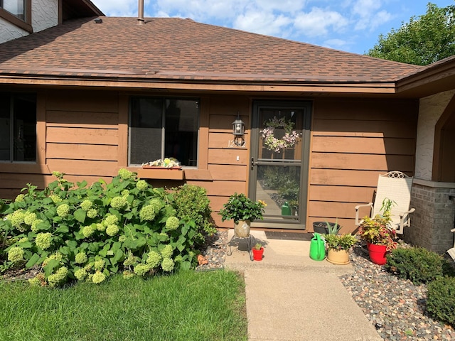 doorway to property featuring roof with shingles