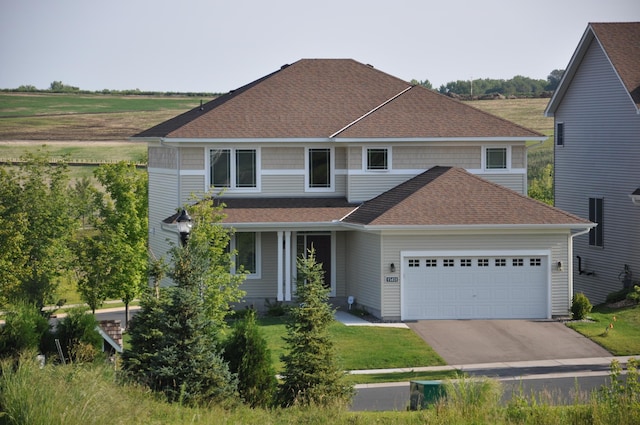 view of front of home with a front yard, concrete driveway, a garage, and a shingled roof