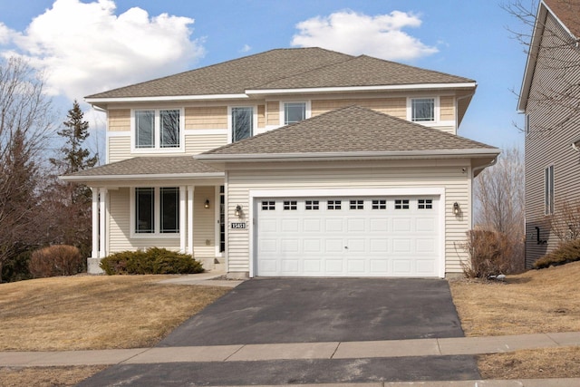 traditional-style home with aphalt driveway, roof with shingles, and an attached garage