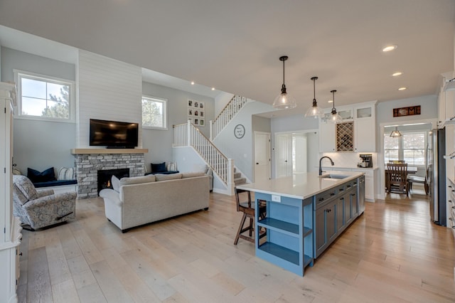 kitchen featuring open floor plan, light countertops, light wood-type flooring, white cabinets, and open shelves