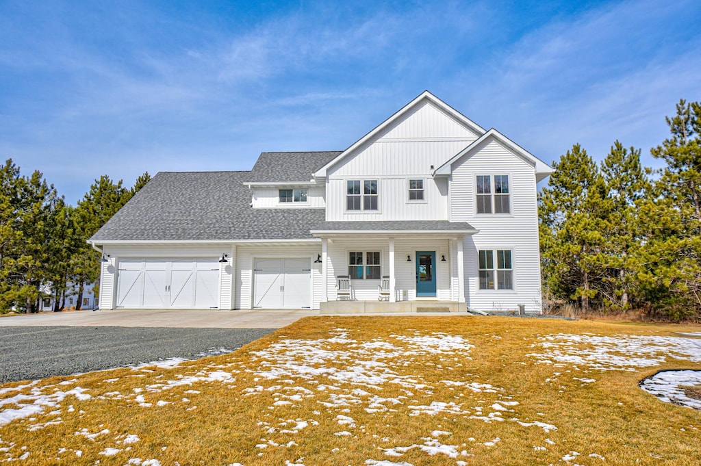 modern farmhouse style home with driveway, roof with shingles, covered porch, and an attached garage