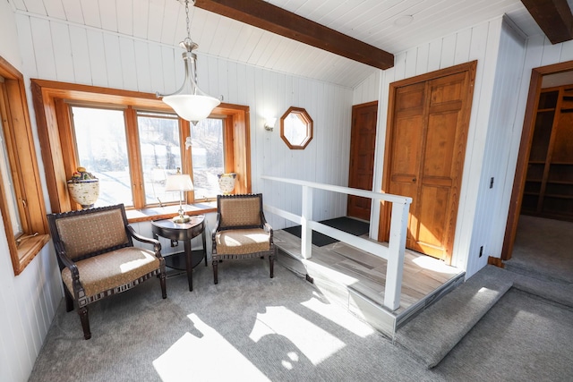 sitting room with beam ceiling and carpet