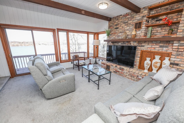 carpeted living area featuring beam ceiling and a brick fireplace