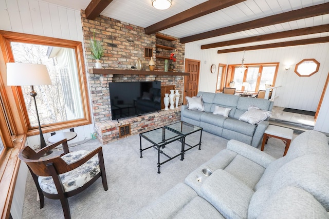 carpeted living area featuring beam ceiling and a brick fireplace