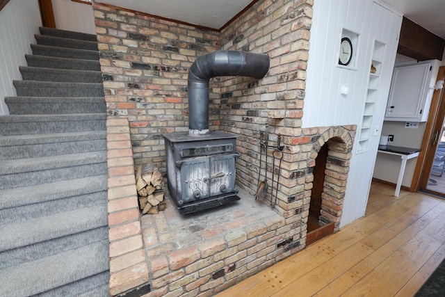 details featuring built in shelves, a wood stove, and wood finished floors