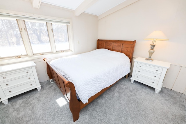 carpeted bedroom with beamed ceiling and a skylight