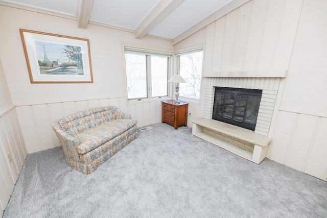 sitting room with a wainscoted wall, carpet floors, vaulted ceiling with beams, a fireplace, and a decorative wall