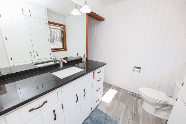 bathroom with visible vents, toilet, and vanity