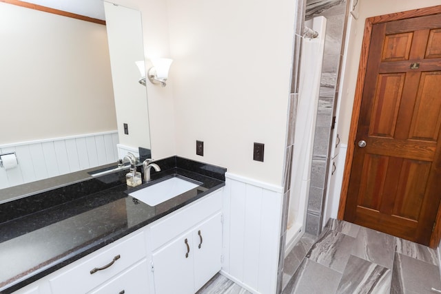 full bath featuring wainscoting, vanity, and a shower stall