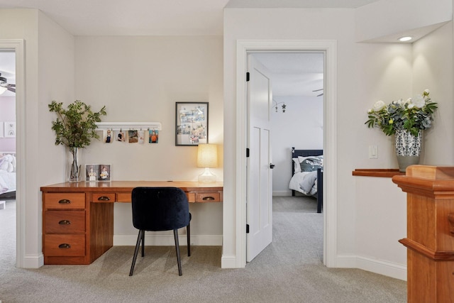 office area with baseboards, light carpet, and built in study area