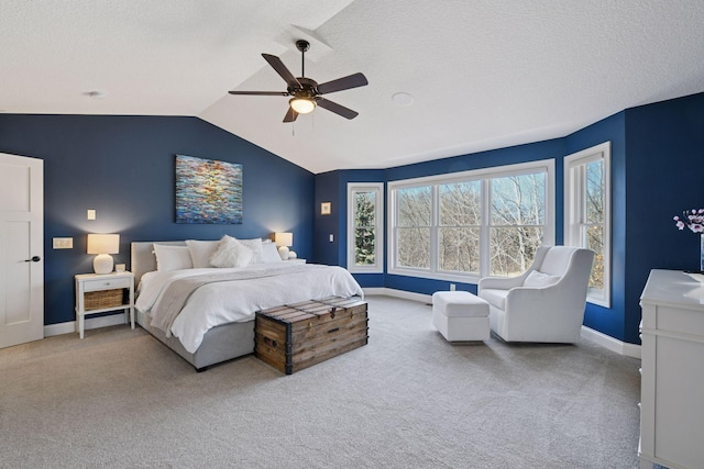 carpeted bedroom with baseboards, a textured ceiling, ceiling fan, and vaulted ceiling