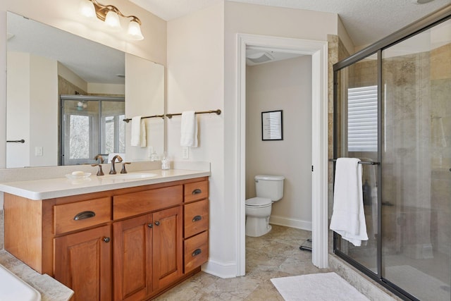 bathroom with vanity, baseboards, a stall shower, a textured ceiling, and toilet