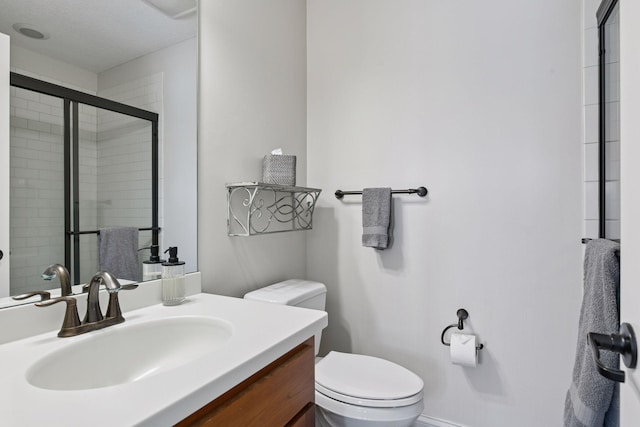 bathroom with vanity, toilet, and a tile shower