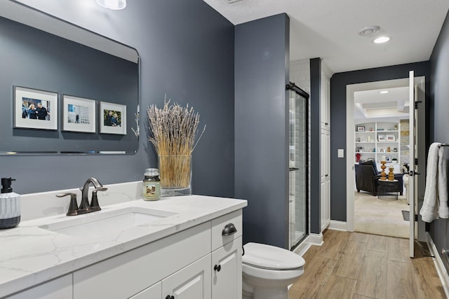 full bathroom with vanity, toilet, wood finished floors, and a shower stall