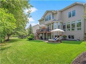 rear view of property with a yard, a wooden deck, and stairs