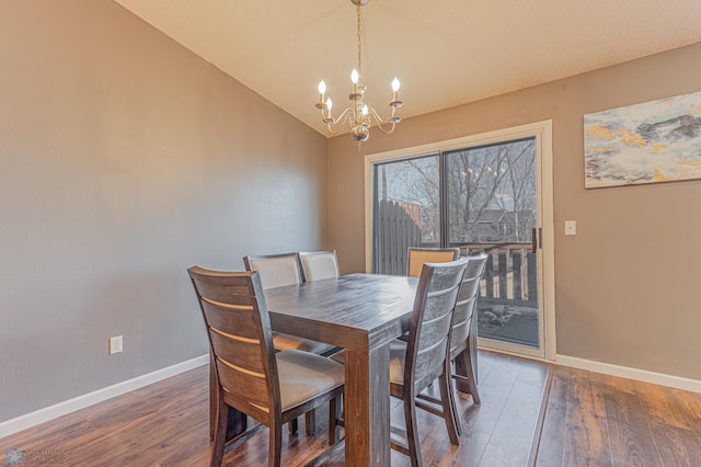 dining room with a notable chandelier, lofted ceiling, baseboards, and wood finished floors