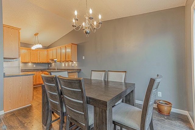 dining area featuring an inviting chandelier, dark wood-style floors, baseboards, and lofted ceiling