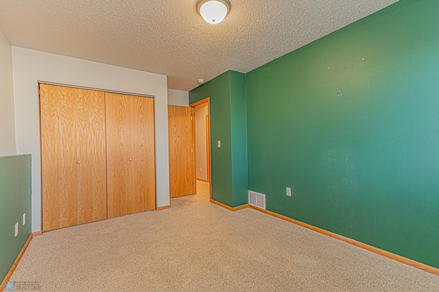 unfurnished bedroom featuring a closet, visible vents, baseboards, and carpet