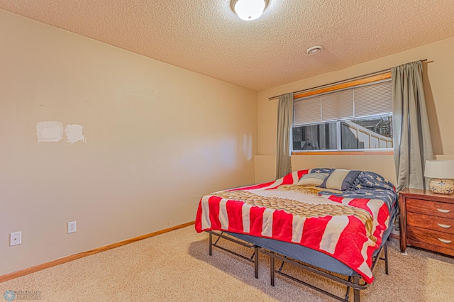 bedroom featuring baseboards, a textured ceiling, and carpet floors