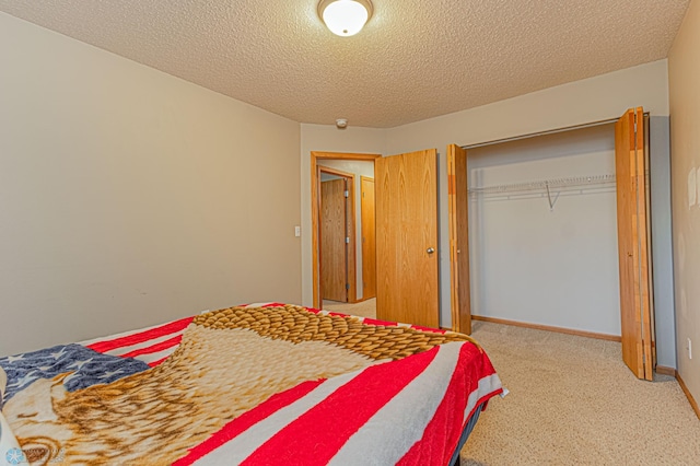 bedroom featuring a closet, baseboards, carpet floors, and a textured ceiling