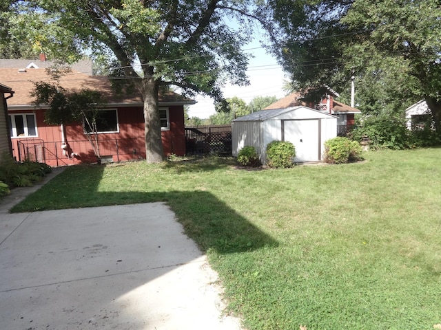 view of yard with a storage shed, an outdoor structure, and fence