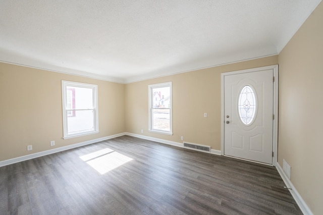 foyer entrance with visible vents, baseboards, and dark wood-style flooring