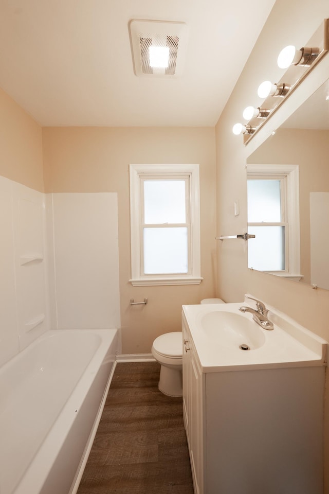 full bath featuring vanity, wood finished floors, visible vents, baseboards, and toilet