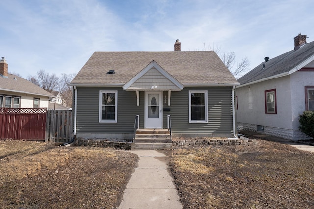 bungalow featuring a chimney, roof with shingles, and fence