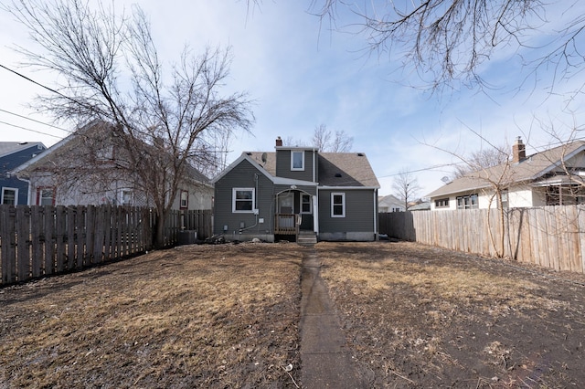 view of front of house featuring a chimney and a fenced backyard