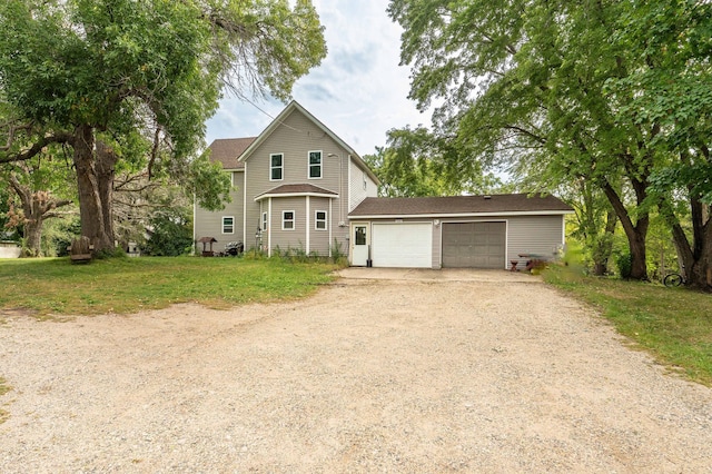 traditional home featuring an attached garage, a front yard, and dirt driveway