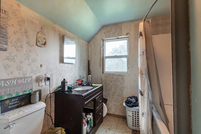 full bathroom featuring toilet, wallpapered walls, baseboards, vanity, and vaulted ceiling