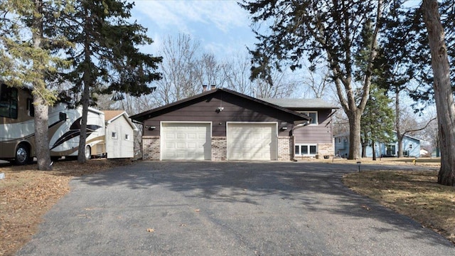 view of side of property featuring brick siding, driveway, and an attached garage