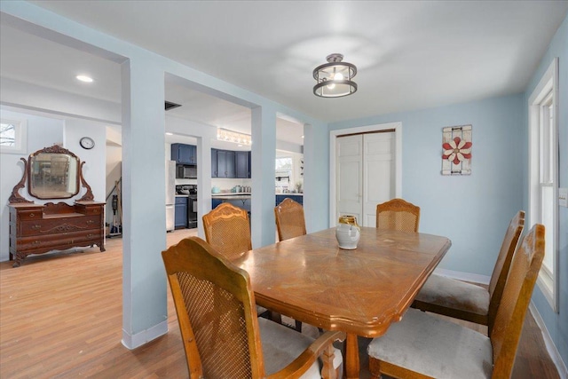 dining room with light wood finished floors and baseboards