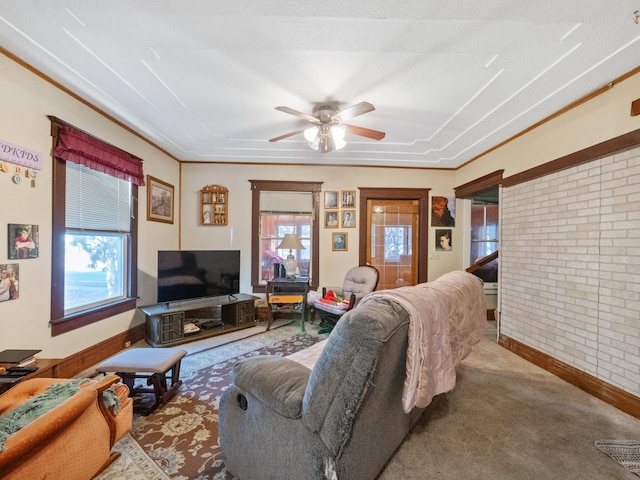 carpeted living area featuring baseboards, brick wall, and a ceiling fan