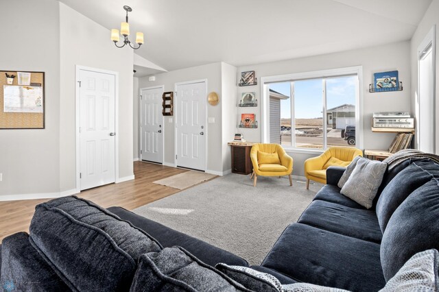 living area featuring a chandelier, baseboards, wood finished floors, and vaulted ceiling