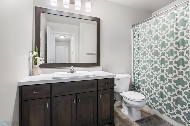 bathroom with vanity, a shower with shower curtain, and toilet