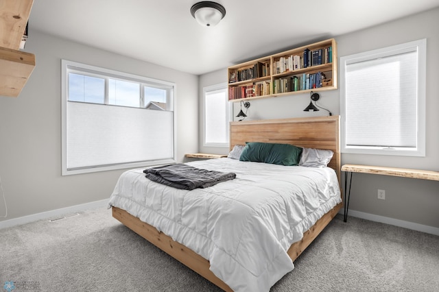 carpeted bedroom with visible vents and baseboards