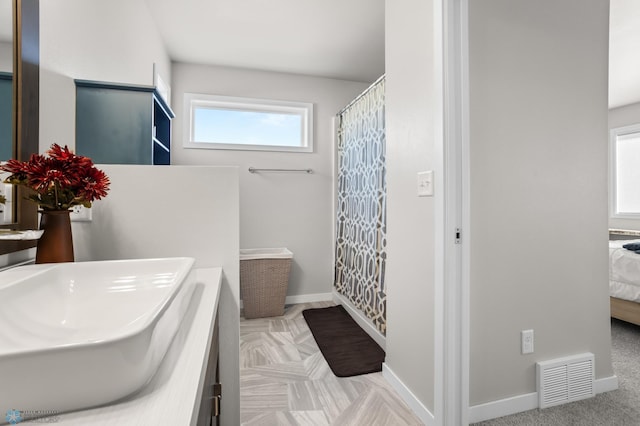 ensuite bathroom with visible vents, curtained shower, connected bathroom, baseboards, and vanity