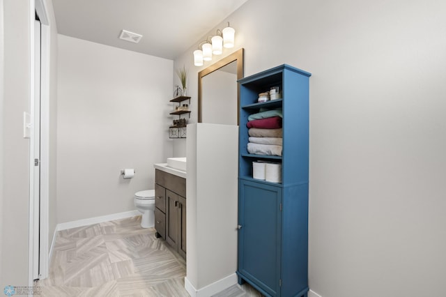 bathroom with visible vents, baseboards, toilet, and vanity