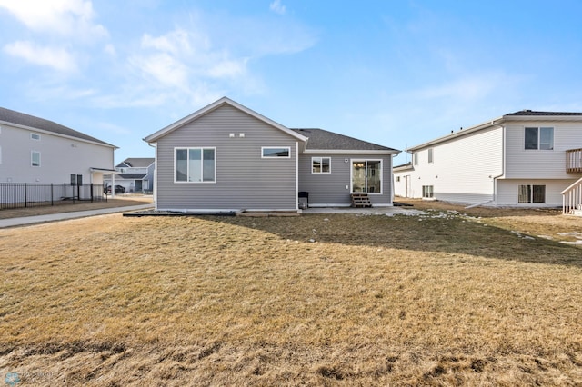 rear view of house with a yard, a patio, and fence