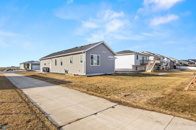 view of home's exterior featuring a residential view, an outdoor structure, and a yard