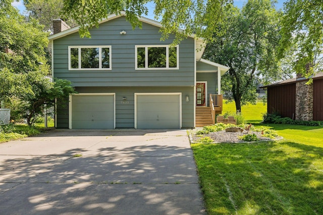 view of front facade with an attached garage, driveway, a chimney, and a front lawn