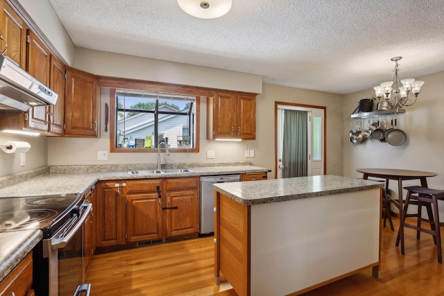 kitchen with a sink, light wood-style floors, brown cabinets, and stainless steel dishwasher