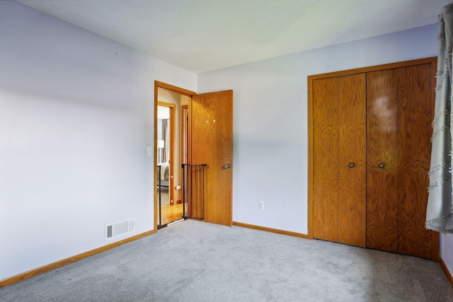 unfurnished bedroom with a closet, baseboards, visible vents, and carpet floors