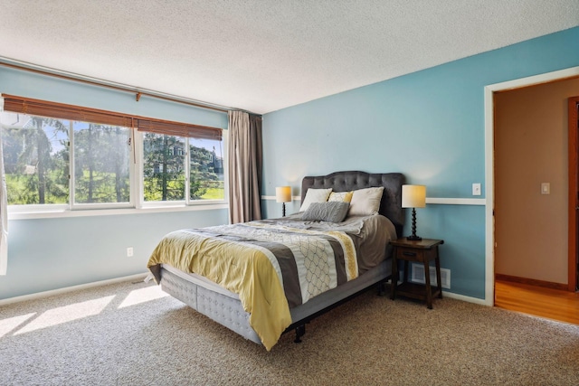 carpeted bedroom featuring visible vents, baseboards, and a textured ceiling