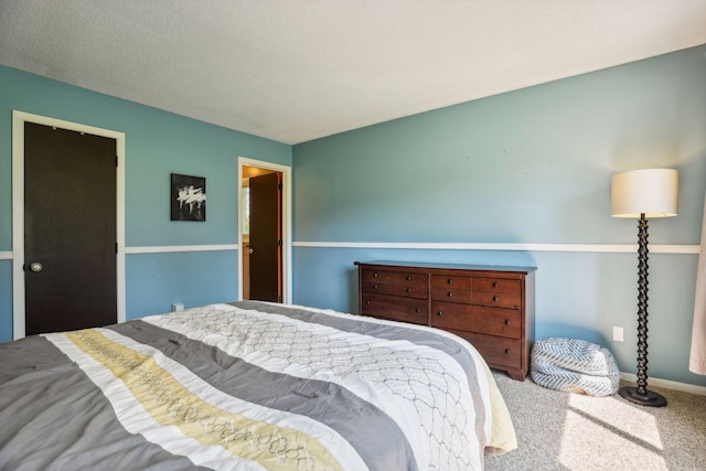 bedroom featuring baseboards, carpet floors, and a textured ceiling