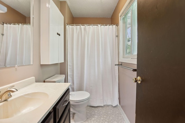 full bath with curtained shower, toilet, vanity, tile patterned floors, and a textured ceiling