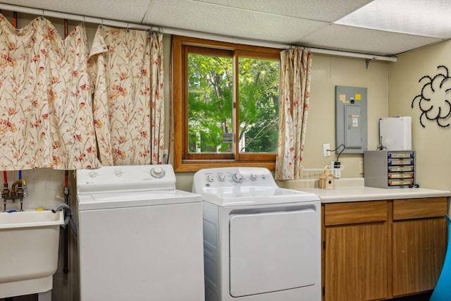 clothes washing area featuring electric panel, cabinet space, independent washer and dryer, and a sink