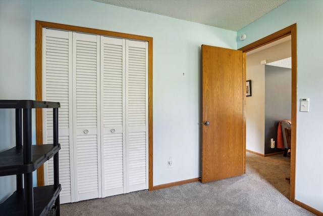 carpeted bedroom with baseboards, a closet, and a textured ceiling